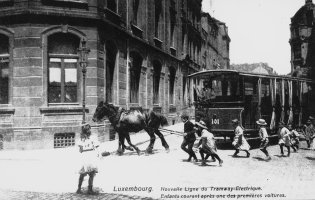 Image de 1908 avec des enfants suivant un tram à cheval