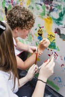 mains d'enfants qui dessinent sur un tableau blanc