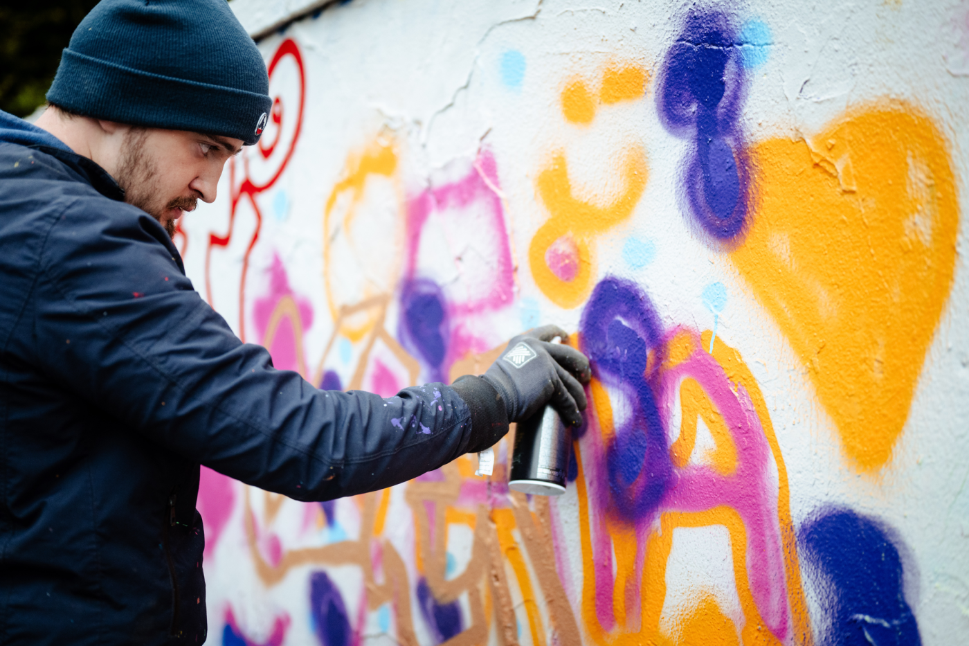 Artiste graffiti en train de peindre un mur