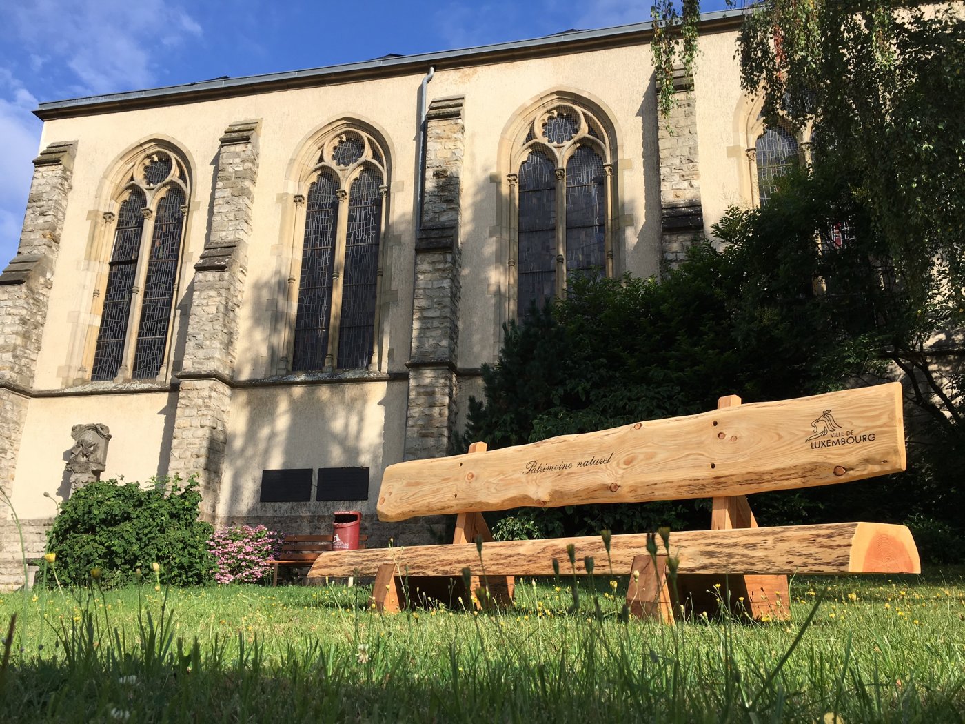 banc en bois devant une église fabriqué dans les ateliers du patrimoine naturel