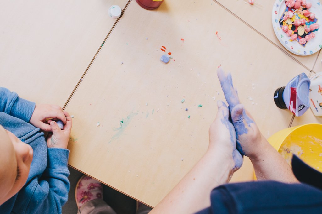 enfant et éducatrice jouant avec de la plasticine