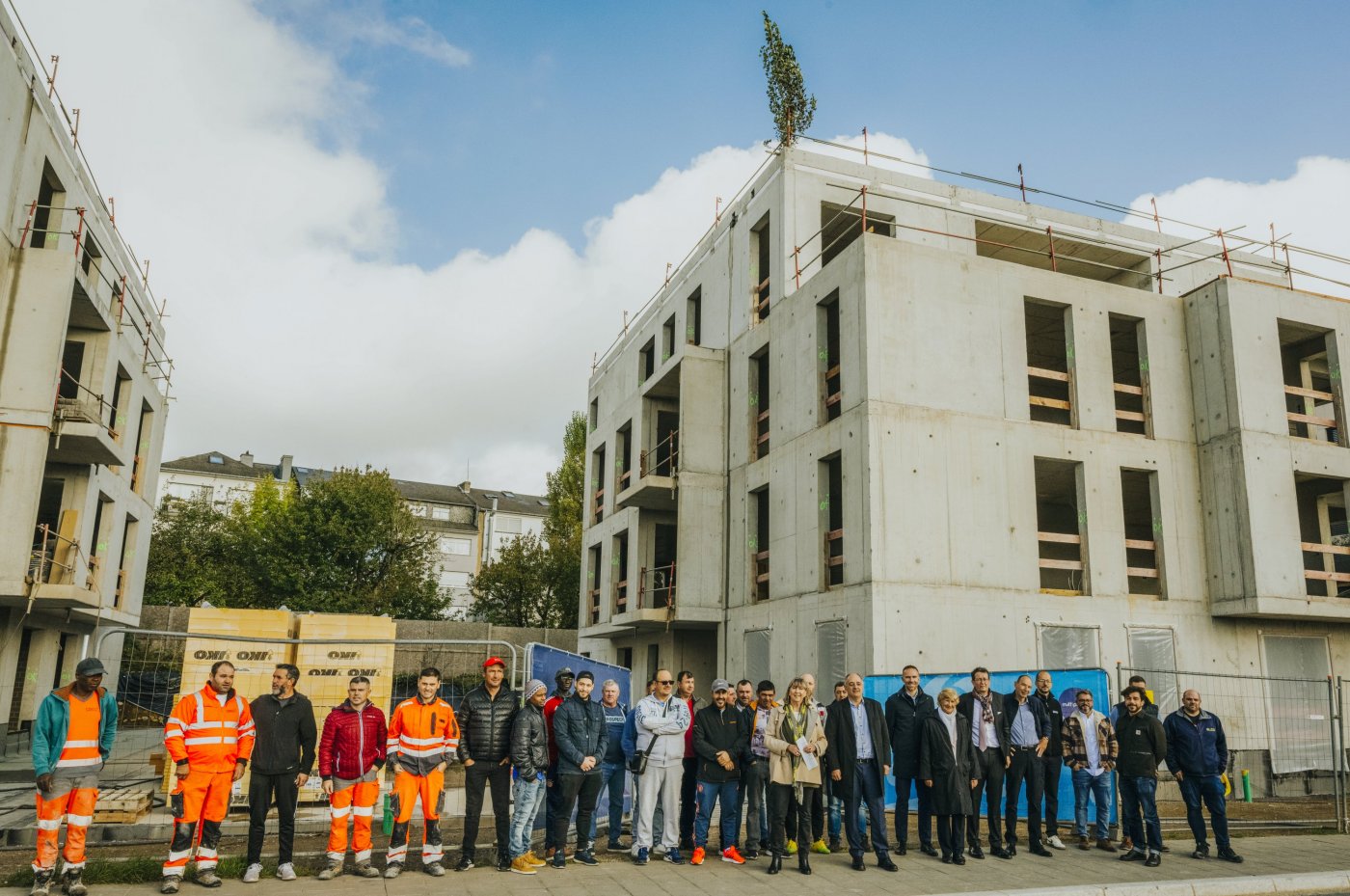Image prise lors de la fête du bouquet avec des membres de la politique et des ouvriers devant la résidence en construction