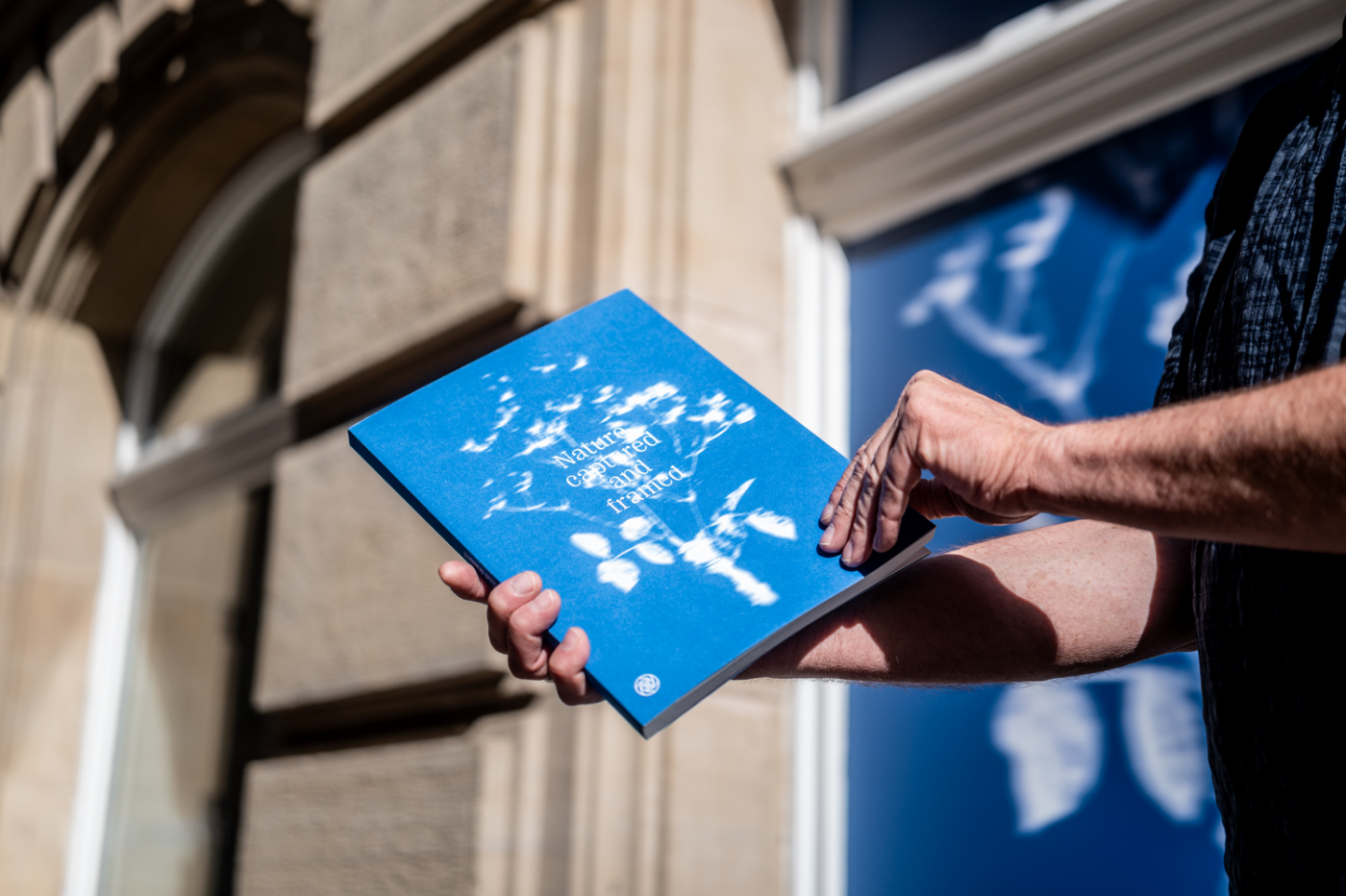 Image du catalogue des photos tenu dans la main devant le cercle cité
