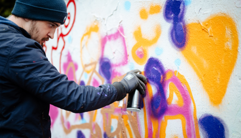 Artiste graffiti en train de peindre un mur