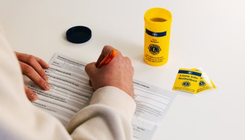 Image d'une personne en train de remplir ses informations sur la fiche de renseignement de la Lions Emergency Box