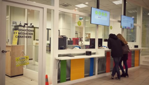 personnes devant guichets de l'Info-Box