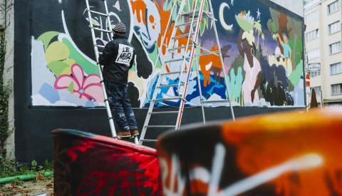 L'artiste Lewoz peint son art grafiti sur un mur