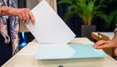 une personne dépose son bulletin de vote