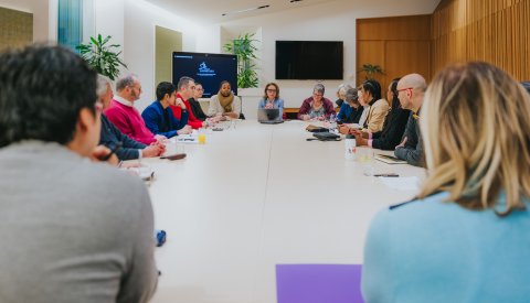 toute la commission assise autour d'un table dans la salle de réunion